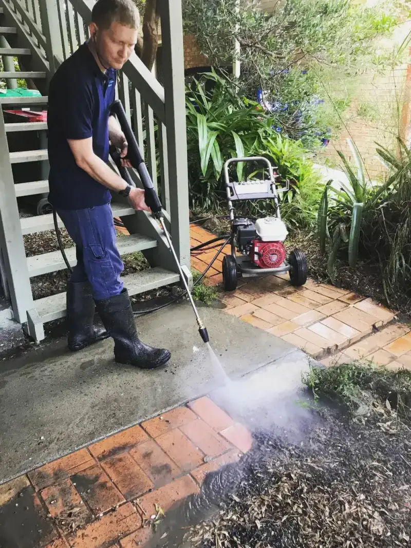 Shannan pressure washing a brick garden path
